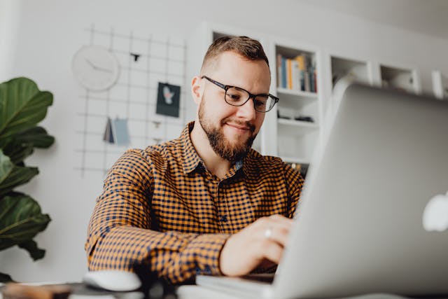 A man using a computer, smiling