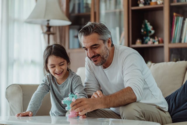 A man and his daughter playing in the living room